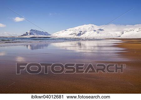 Stock Image - "Sunny winter day on the sandy beach in front of Snaefellsjokull volcano, Snaefellsnes Peninsula, Iceland, Europe". Fotosearch