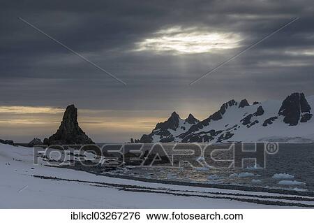 Stock Photograph - "Sunrays shining through a hole in the clouds at Half Moon Island, Sudliche Shetlandinseln, Antarctica". Fotosearch