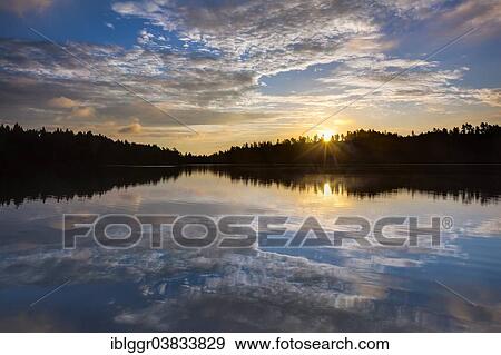 Stock Photo - "Sunrise at a lake, near Ed, Dalsland, Vastra Gotaland, Sweden, Europe". Fotosearch