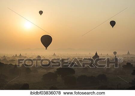 "Sunrise, hot air balloons over the landscape in the early morning fog, temples, stupas, pagodas, temple complex, Plateau of Bagan, Mandalay Division, Burma or Myanmar" View Large Photo Image Stock Photo - "Sunrise, hot air balloons over the landscape in the early morning fog, temples, stupas, pagodas, temple complex, Plateau of Bagan, Mandalay Division, Burma or Myanmar". Fotosearch