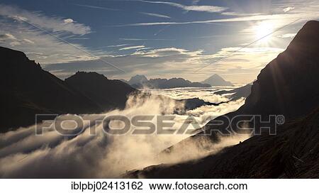 Stock Image - Sunrise near Marmolada Mountain, fog, Dolomites, Italy, Europe. Fotosearch