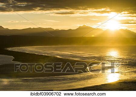 "Sunrise on the coast of the Indian Ocean, reflections of sun rays in the water, mountain ridge, Plettenberg Bay or Plettenbergbaai, Garden Route, Eden District, Western Cape, South Africa, Africa" View Large Photo Image Stock Image - "Sunrise on the coast of the Indian Ocean, reflections of sun rays in the water, mountain ridge, Plettenberg Bay or Plettenbergbaai, Garden Route, Eden District, Western Cape, South Africa, Africa". Fotosearch
