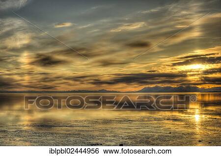 Stock Photograph - "Sunset and halos over Cook Inlet, Alaska". Fotosearch