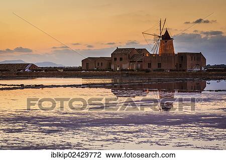 Stock Image - "Sunset at the old saltworks in the Laguna dello Stagnone near Trapani, Sicily, Italy, Europe". Fotosearch
