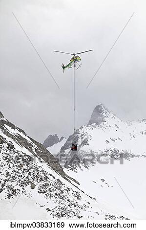 "Supplies are carried by helicopter in a transport net to the Cavardiras hut, mountain refuge, above the glacier at Cavardiras, Graubunden, Switzerland, Europe" View Large Photo Image Stock Photo - "Supplies are carried by helicopter in a transport net to the Cavardiras hut, mountain refuge, above the glacier at Cavardiras, Graubunden, Switzerland, Europe". Fotosearch