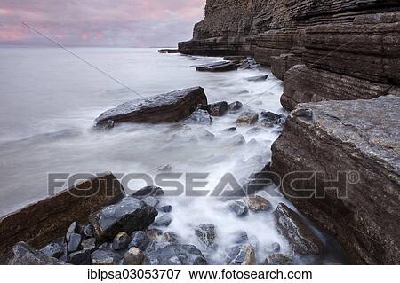 Stock Photo - "Surf on the rocky coast with cliffs, Dunraven Bay, Glamorgan Heritage Coast, Wales, United Kingdom, Europe". Fotosearch