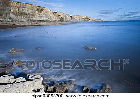Stock Image - "Surf with cliffs, Dunraven Bay, Glamorgan Heritage Coast, Wales, United Kingdom, Europe". Fotosearch