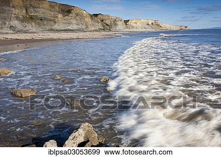Stock Photo - "Surf with cliffs, Dunraven Bay, Glamorgan Heritage Coast, Wales, United Kingdom, Europe". Fotosearch