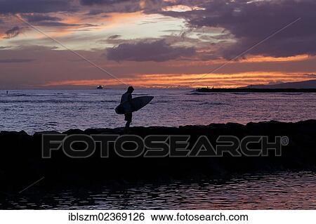 Stock Photograph - "Surfer in front of the sunset, Waikiki, Honolulu, O'ahu, Hawai'i, USA, America". Fotosearch