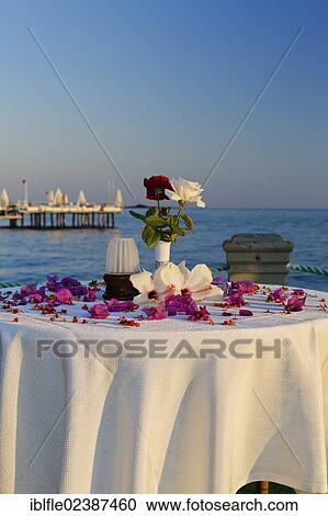 Stock Image - "Table decorated with flowers on a jetty on the Turkish Riviera, Turkey, Asia". Fotosearch
