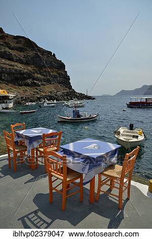"Tables and chairs of the """"Katina"""" restaurant in the Ammoudi harbour of Oia, Santorini, Cyclades, Greek Islands, Greece, Europe" View Large Photo Image Stock Photo - "Tables and chairs of the """"Katina"""" restaurant in the Ammoudi harbour of Oia, Santorini, Cyclades, Greek Islands, Greece, Europe". Fotosearch