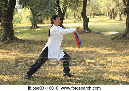 "Tai Chi with a sword, demonstration in an olive grove, Regine Zanini, two-time silver medalist at the Tai Chi Championships 2012, Menton, French Riviera, Alpes-Maritimes, Provence-Alpes-Cote d’Azur, France, Europe" View Large Photo Image Stock Image - "Tai Chi with a sword, demonstration in an olive grove, Regine Zanini, two-time silver medalist at the Tai Chi Championships 2012, Menton, French Riviera, Alpes-Maritimes, Provence-Alpes-Cote d’Azur, France, Europe". Fotosearch