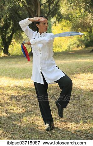 Stock Photo - "Tai Chi with a sword, demonstration in an olive grove, Regine Zanini, two-time silver medalist at the Tai Chi Championships 2012, Menton, French Riviera, Alpes-Maritimes, Provence-Alpes-Cote dâ€™Azur, France, Europe". Fotosearch