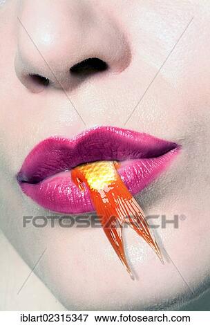 Tail of a goldfish hanging out of a woman's mouth View Large Photo Image Stock Photo - Tail of a goldfish hanging out of a woman's mouth. Fotosearch