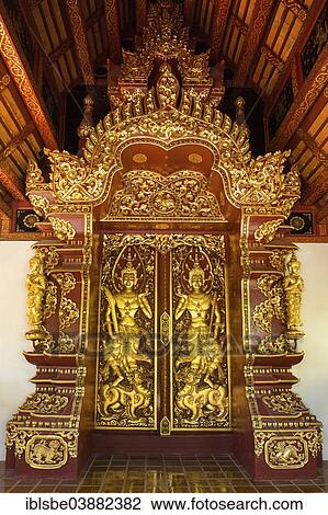 Stock Image - "Teak entrance gate decorated with gold leaf in Wat Phrah Singh Temple, Chiang Rai, Chiang Rai province, Northern Thailand, Thailand, Asia". Fotosearch