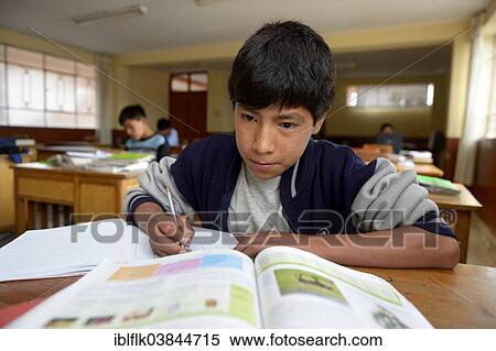 Stock Photography - "Teenage boy, 13 years, doing his homework in the classroom at a children's home, Ayacucho, Ayacucho region, Peru, South America". Fotosearch