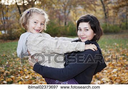 "Teenage girl, 14 years, holding girl, 6 years, in her arms" View Large Photo Image Stock Photo - "Teenage girl, 14 years, holding girl, 6 years, in her arms". Fotosearch