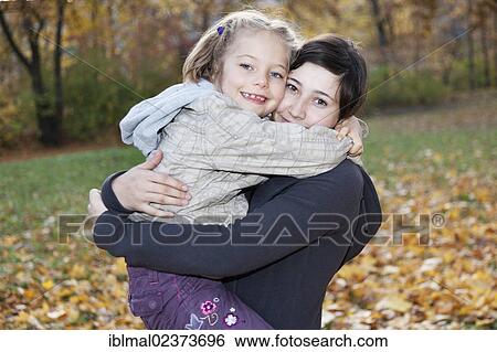 "Teenage girl, 14 years, holding girl, 6 years, in her arms" View Large Photo Image Stock Photograph - "Teenage girl, 14 years, holding girl, 6 years, in her arms". Fotosearch