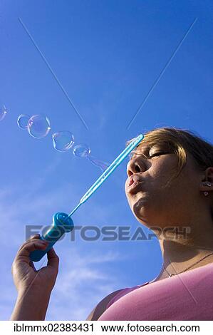 "Teenager blowing soap bubbles, Germany, Europe" View Large Photo Image Stock Image - "Teenager blowing soap bubbles, Germany, Europe". Fotosearch