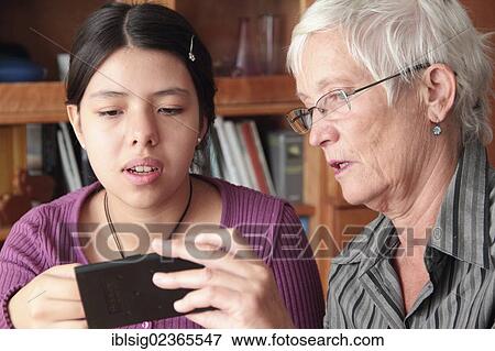 Teenager explaining the use of an iPad to a senior citizen View Large Photo Image Stock Photo - Teenager explaining the use of an iPad to a senior citizen. Fotosearch