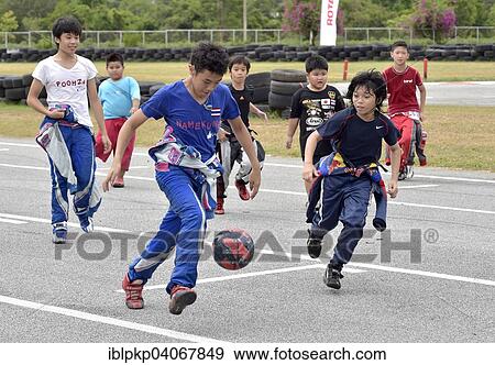 "Teenager in racing overalls playing football, Pattaya, Thailand, Asia" View Large Photo Image Stock Photo - "Teenager in racing overalls playing football, Pattaya, Thailand, Asia". Fotosearch