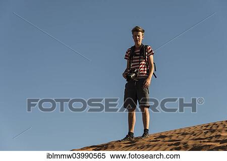 "Teenager with photo camera standing on a dune, Sossusvlei, Namib Desert, Namibia, Africa" View Large Photo Image Stock Photography - "Teenager with photo camera standing on a dune, Sossusvlei, Namib Desert, Namibia, Africa". Fotosearch