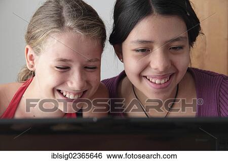 Teenagers on a laptop computer View Large Photo Image Stock Photograph - Teenagers on a laptop computer. Fotosearch