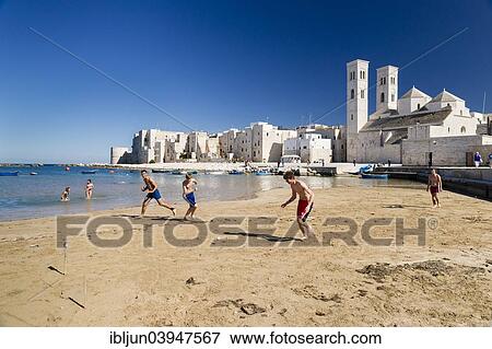 "Teenagers playing football onthe beach, harbor, historic centre, Romanesque Old Cathedral, San Corrado and Torrione Passari, Molfetta, Bari Province, Apulia, Italy, Europe" View Large Photo Image Stock Photo - "Teenagers playing football onthe beach, harbor, historic centre, Romanesque Old Cathedral, San Corrado and Torrione Passari, Molfetta, Bari Province, Apulia, Italy, Europe". Fotosearch