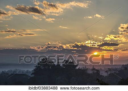 Stock Photo - "Temples, pagodas and trees in the mist, at sunset, Mrauk U, Sittwe District, Rakhine State, Myanmar, Asia". Fotosearch