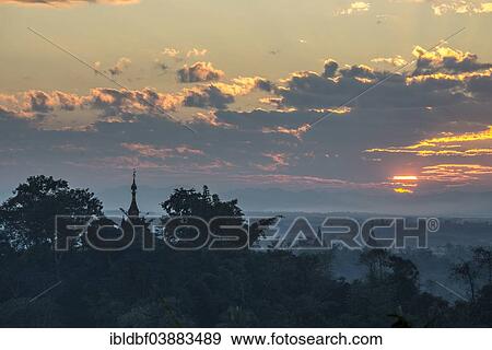 Stock Photo - "Temples, pagodas and trees in the mist, at sunset, Mrauk U, Sittwe District, Rakhine State, Myanmar, Asia". Fotosearch