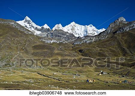 Stock Photo - "Tent camp, at the back the snow-capped Mt Trapecio and Mt Nevados Jurau, Cordillera Huayhuash mountain range, Northern Peru, Peru, South America". Fotosearch