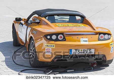 "Tesla Roadster, an American electric sports car having its batteries charged before the prologue of the e-miglia 2012 from Munich to St. Moritz, Munich, Bavaria, Germany, Europe" View Large Photo Image Stock Photography - "Tesla Roadster, an American electric sports car having its batteries charged before the prologue of the e-miglia 2012 from Munich to St. Moritz, Munich, Bavaria, Germany, Europe". Fotosearch