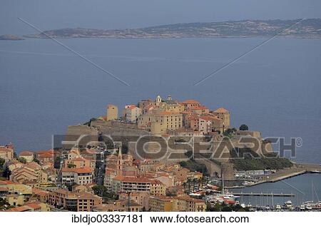 Stock Image - "The citadel (castle) of Calvi surrounded by the mediterranean sea. Calvi is in the department Haute-Corse, France on the mediterranean island of Corsica, La Vaccaja, Calvi, Corsica, France, Europe". Fotosearch