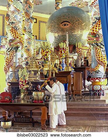 Stock Image - "The Divine Eye in the Cao Dai Temple, during a mass with worshippers, Caodaiism, Tay Ninh, Sudvietnam, Vietnam, Asia". Fotosearch