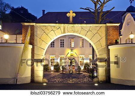 Stock Photo - "The illuminated gate to Engelsburg castle, at dusk, historic center, Recklinghausen, North Rhine-Westphalia, Germany, Europe". Fotosearch