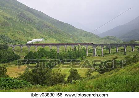 Stock Photograph - "The Jacobite, steam train, travelling over Glenfinnan Viaduct, made famous in the Harry Potter films, Ross, Skye and Lochaber, Scottish Highlands, Scotland, United Kingdom, Europe". Fotosearch