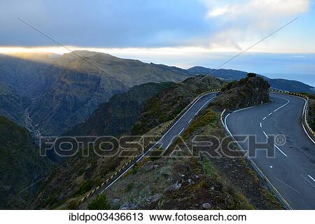 Stock Image - "The mountainous road leading to Paul da Serra at dawn, with a view to the sea and the Serra de Agua village in the valley below, Madeira, Portugal, Europe". Fotosearch