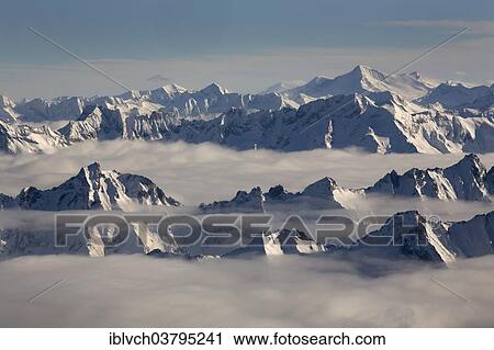 Stock Image - "The peaks of the Zillertal Alps rising above the sea of â€‹â€‹fog, behind the Venediger Group, Hohe Tauern, from the Hintertux glacier, Zillertal, Tyrol, Austria, Europe". Fotosearch