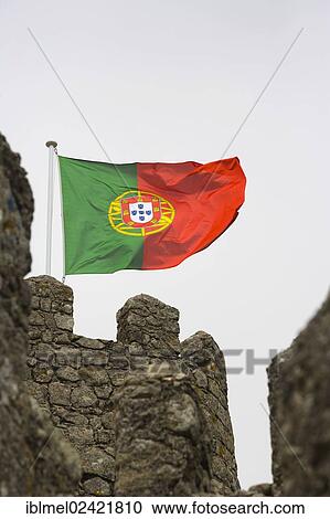 Stock Image - The Portuguese flag on the wall of the Moorish Castle, Castle of the Moors, Castelo dos Mouros, Sintra Cascais Natural Park, Grande Lisboa, Lisbon Region, Portugal, Europe. Fotosearch