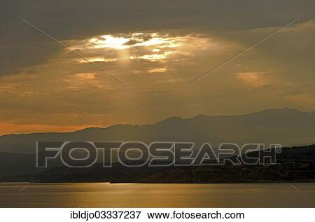 "The rising sun forms sun beams behind the rocks of the island Ile de la Pietra near L'Ile-Rousse. L'Ile-Rousse is in the department Haute-Corse, France on the mediterranean island of Corsica, Ile de la Pietra, L’Ile-Rousse, Corsica, France, Europe" View Large Photo Image Stock Photo - "The rising sun forms sun beams behind the rocks of the island Ile de la Pietra near L'Ile-Rousse. L'Ile-Rousse is in the department Haute-Corse, France on the mediterranean island of Corsica, Ile de la Pietra, L’Ile-Rousse, Corsica, France, Europe". Fotosearch