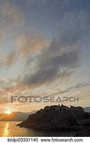 "The silhouette of the citadel (castle) of Calvi surrounded by the mediterranean sea in front of a colorful sunrise. Calvi is in the department Haute-Corse, France on the mediterranean island of Corsica, Calvi, Corsica, France, Europe" View Large Photo Image Stock Image - "The silhouette of the citadel (castle) of Calvi surrounded by the mediterranean sea in front of a colorful sunrise. Calvi is in the department Haute-Corse, France on the mediterranean island of Corsica, Calvi, Corsica, France, Europe". Fotosearch