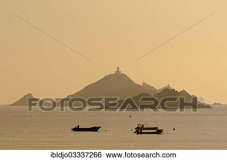 Stock Photograph - "The silhouette of the islands Les Iles Sanguinaires with small boats in the foreground. Les Iles Sanguinaires are in the department Corse-du-Sud, France on the mediterranean island of Corsica, Pisinale, Ajaccio, Corsica, France, Europe". Fotosearch