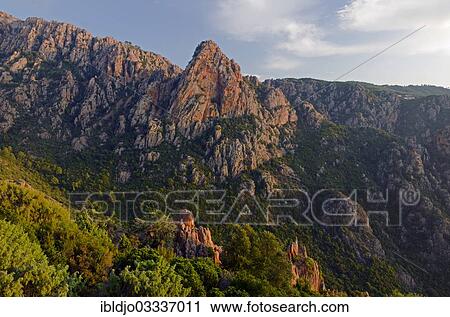 Stock Image - "The typical bizarre red rocks of the Calanche of Pianasurrounded by green scrub. The Calanche of Piana is in the western part of the island Corsica, France, Calanques de Piana, Piana, Corsica, France, Europe". Fotosearch
