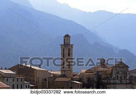 Stock Image - "The village of Montemaggiore dominated by the tower of its church in front of the steep mountains of Corsica, Montemaggiore, Corsica, France, Europe". Fotosearch