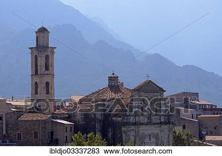 Stock Image - "The village of Montemaggiore dominated by the tower of its church in front of the steep mountains of Corsica, Montemaggiore, Corsica, France, Europe". Fotosearch