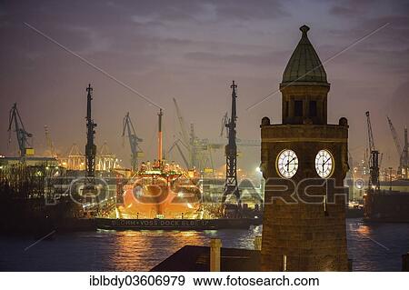 "The Water Level Tower of the St. Pauli Landing Stages in front of the dry dock of the Blohm and Voss Shipyards with the ship Petrojarl Banff in the dock, at dusk, St. Pauli, Hamburg, Hamburg, Germany, Europe" View Large Photo Image Stock Photo - "The Water Level Tower of the St. Pauli Landing Stages in front of the dry dock of the Blohm and Voss Shipyards with the ship Petrojarl Banff in the dock, at dusk, St. Pauli, Hamburg, Hamburg, Germany, Europe". Fotosearch