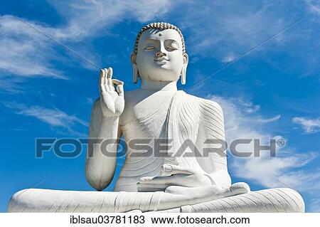 Stock Image - "Theravada Buddhism, white statue of Buddha seated in the lotus position, meditation, gesture of teaching, Dharmachakra Mudra, Buddhist monastery complex of Mihintale, Anuradhapura, Sri Lanka, Asia". Fotosearch