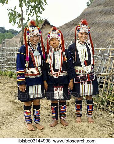 Stock Photo - "Three Akha girls in a mountain village, in traditional costume and headdress, Chiang Rai Province, Northern Thailand, Thailand, Asia". Fotosearch