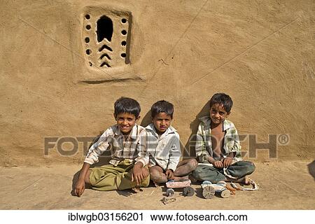 "Three boys sitting outside a mud house, home-made toy cars in front of them, Wuste Thar, Rajasthan, India, Asia" View Large Photo Image Stock Image - "Three boys sitting outside a mud house, home-made toy cars in front of them, Wuste Thar, Rajasthan, India, Asia". Fotosearch