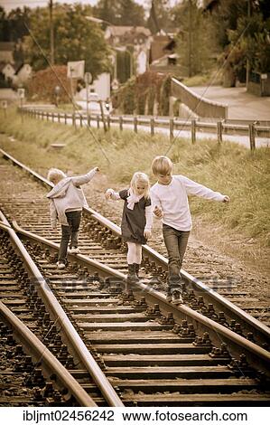"Three children walking on railway lines, sepia-coloured" View Large Photo Image Stock Image - "Three children walking on railway lines, sepia-coloured". Fotosearch